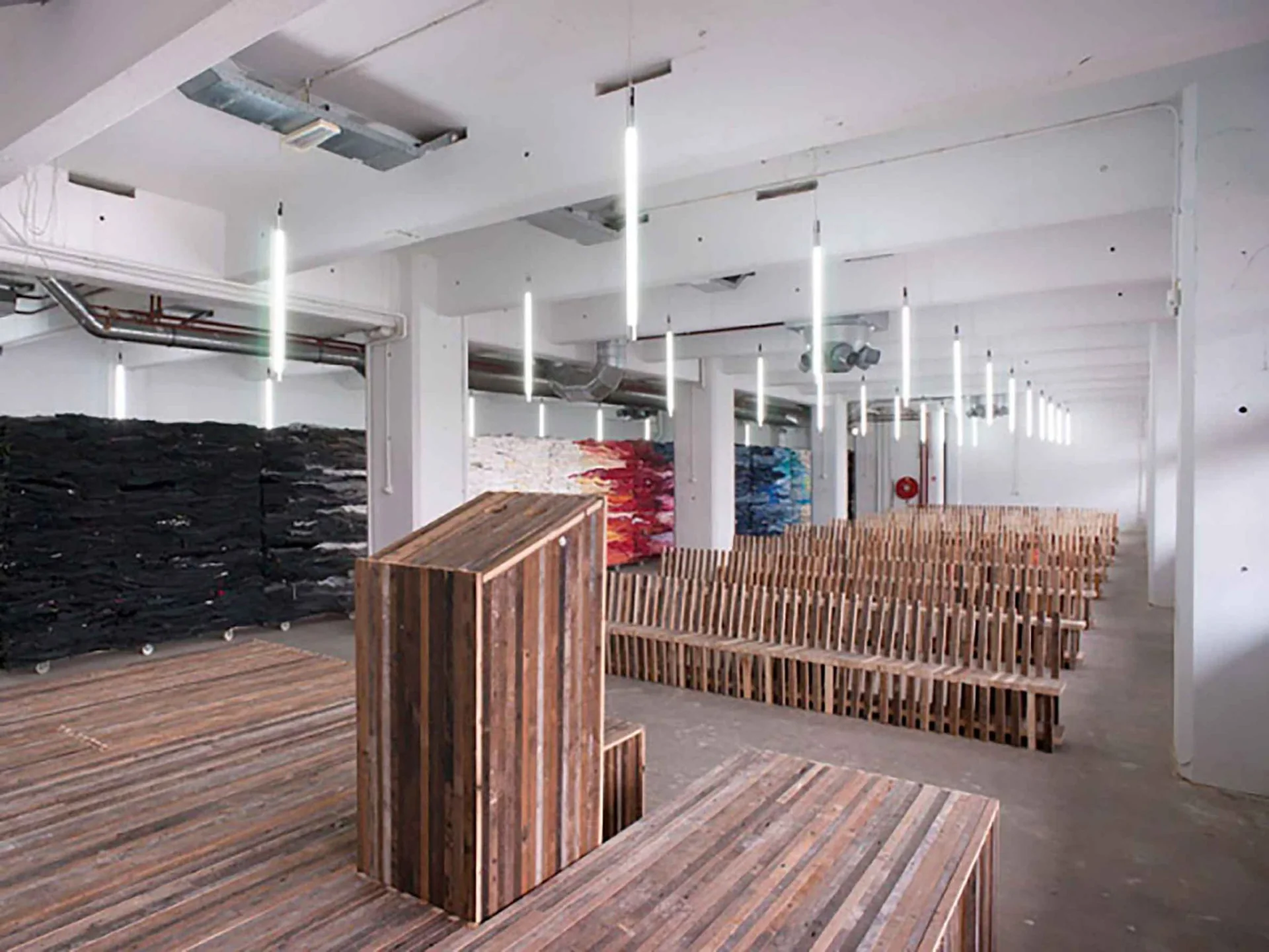 Bijeenkomstruimte met hergebruikte houten inrichting en kunst in het HAKA-gebouw
