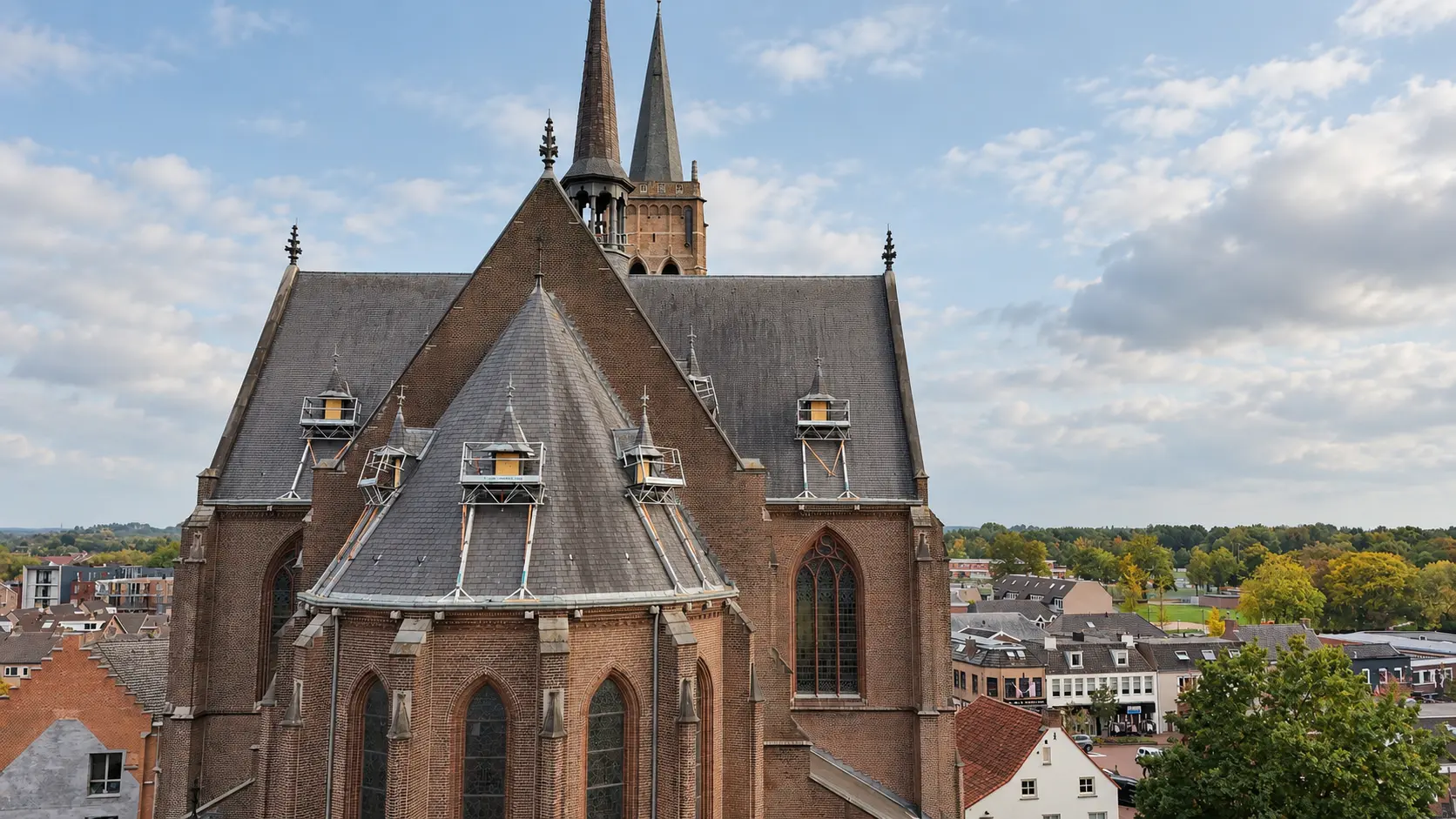 De Sint-Laurentiuskerk in Oud Gastel met twee spitse torens boven het dorp
