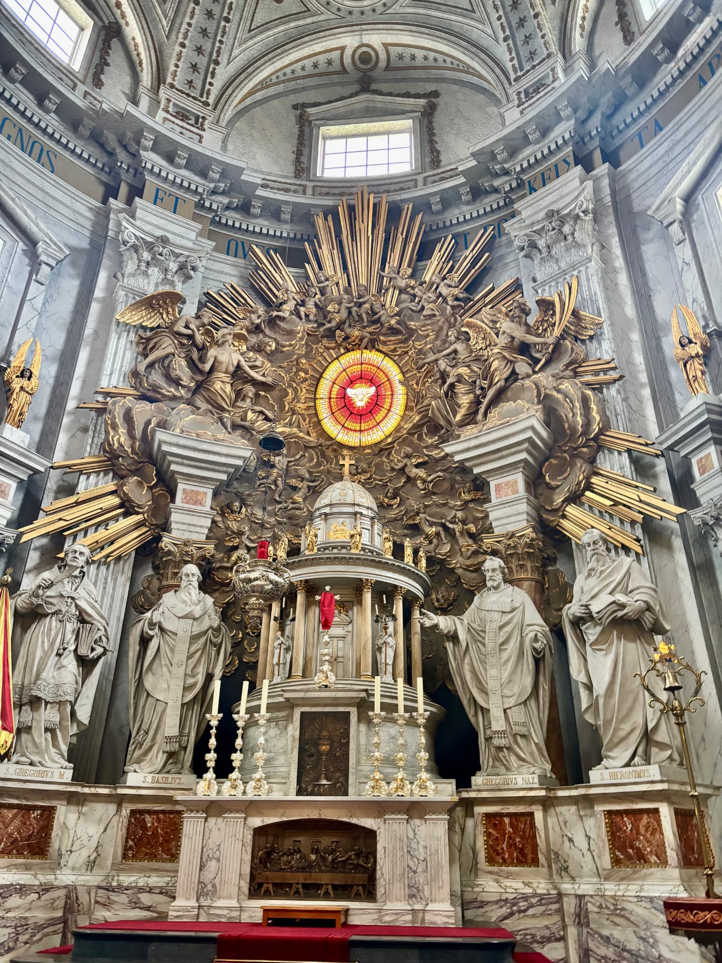 Rijk gedecoreerd altaar met heiligenbeelden, engelen en glas-in-lood in de Basiliek